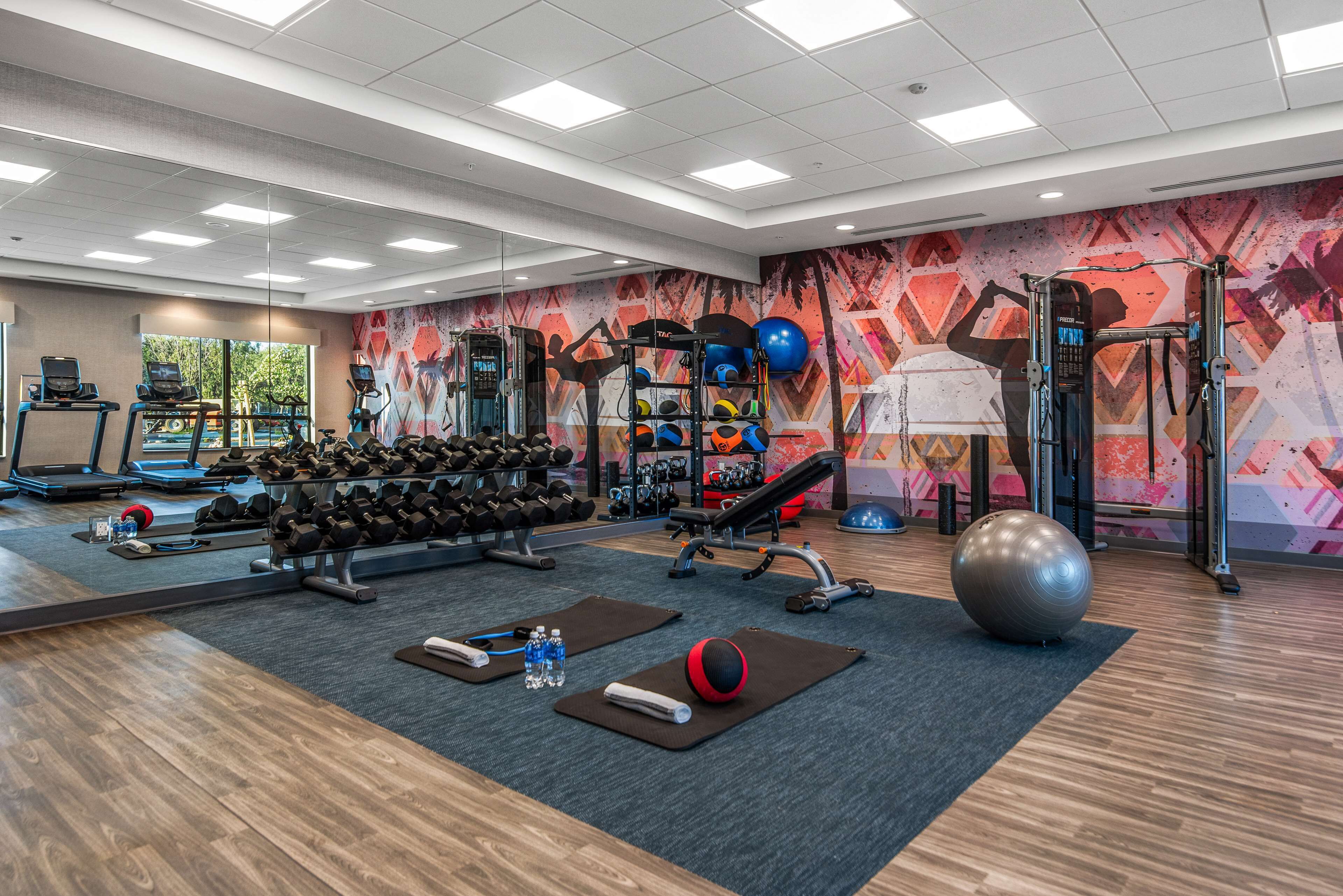 A gym with treadmills, dumbbells, exercise balls, and a variety of workout equipment.