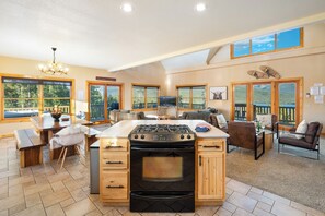 A spacious kitchen with a central island, large windows, and a view of the outdoors.