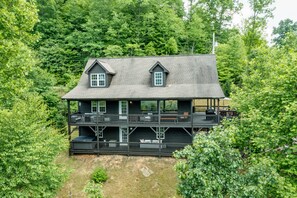Escape to a secluded cabin surrounded by lush forest, with a balcony offering scenic views of the trees.