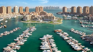 A marina with numerous boats docked, surrounded by high-rise buildings and a clear sky. - The St. Regis Marsa Arabia Island, The Pearl Qatar (Doha)