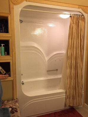 Combined shower/bathtub, towels, soap, toilet paper
