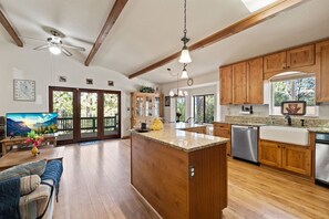 Una cocina amplia con gabinetes de madera, encimera de granito y lavavajillas integrado.