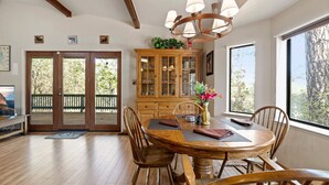 A dining area with a wooden table and chairs, a wooden cabinet with glass doors, and a chandelier. - Yosemite Family Retreat: Dogs OK! Games, Lake, Deers, Golf, Family Reunion! (Groveland)