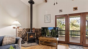 A cozy living room with a fireplace, a sofa, a coffee table, and a television. - Yosemite Family Retreat: Dogs OK! Games, Lake, Deers, Golf, Family Reunion! (Groveland)