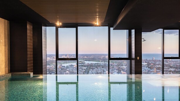 Ein geräumiger Innenpool mit Blick auf die Stadt, großen Fenstern und einem modernen Deckenstil.