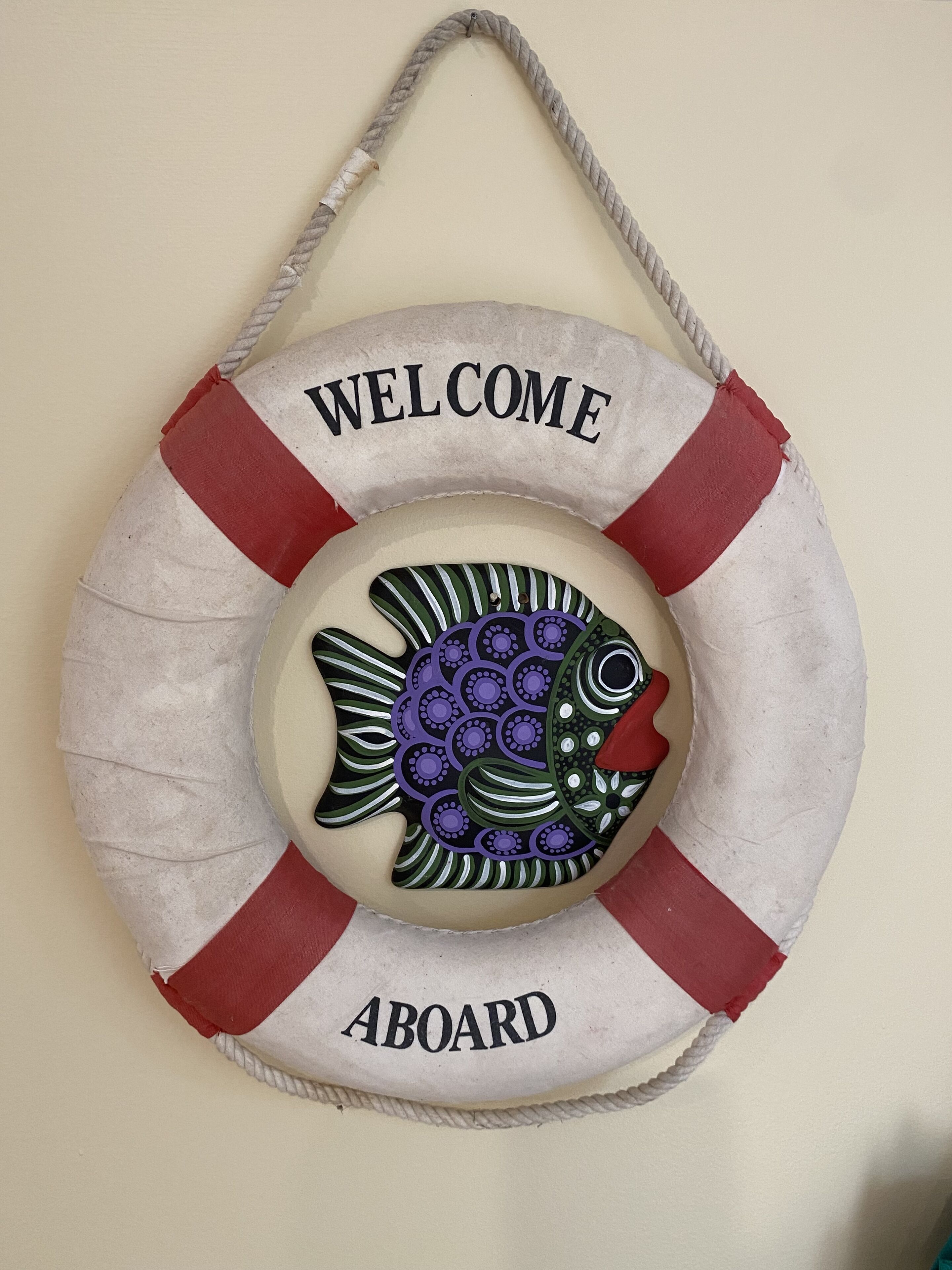 A life preserver with "WELCOME ABOARD" text and a fish design.