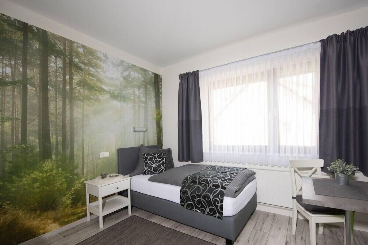 Ein Schlafzimmer mit einem Bett, einem Nachttisch, einem Schreibtisch und einem Stuhl.