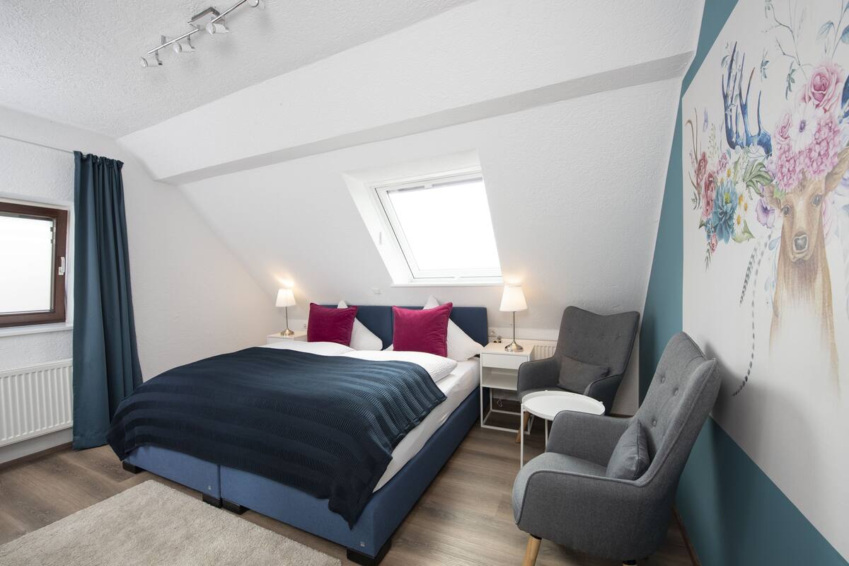Ein modernes Schlafzimmer mit Bett, Schreibtisch und Stuhl.
