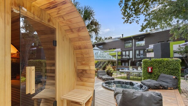 Una sauna in legno con una panca e un'area idromassaggio con cuscini.