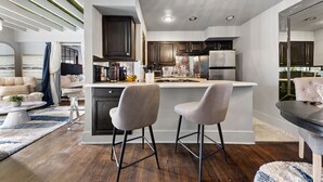 A modern kitchen with a central island, dark wooden cabinets, and a white countertop.