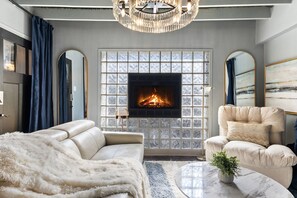 A living room with a fireplace, a sofa, a chair, and a coffee table.