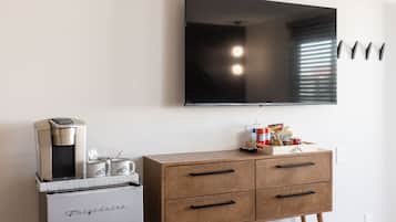A kitchenette with a coffee maker, a mini-fridge, and a cabinet with drawers.