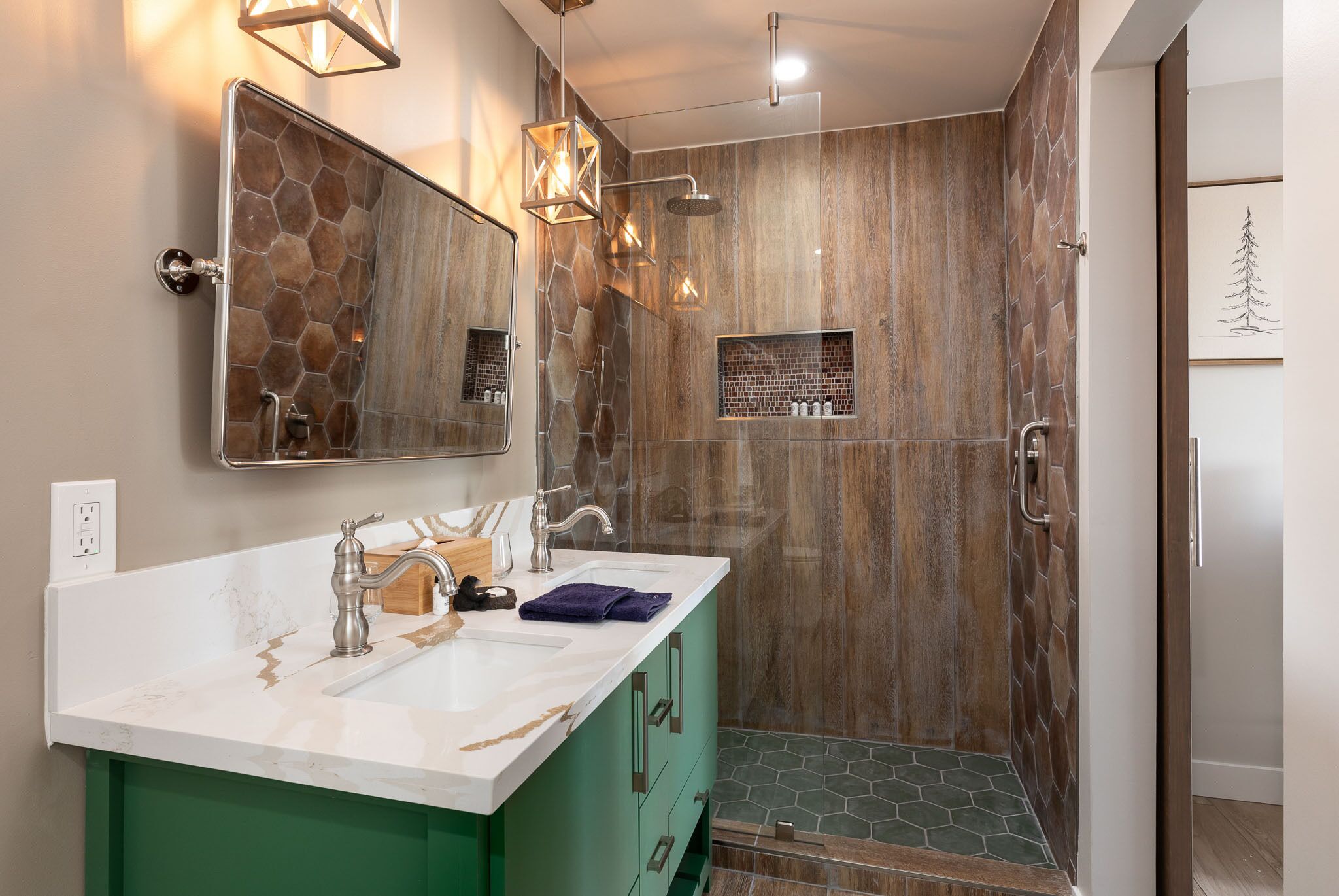 A modern bathroom with a large mirror, two sinks, and a shower area with a wooden wall design.