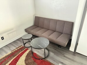 A room with a grey sofa, two round tables with marble tops, and a striped rug. - Newley remodeled and furnished home! (fresno)