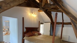 A bedroom with a four-poster bed, a wooden ceiling, and a tiled floor. - Country house next to a golf course, in the Fontainebleau region. (Voulx)