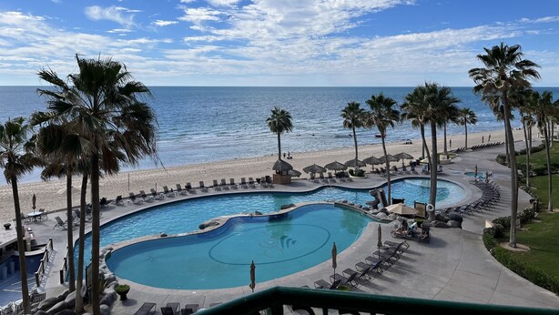Ein Poolbereich mit Blick auf Strand und Meer.