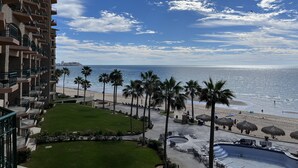 Ein Resort mit Pool, Palmen und Blick auf den Strand.