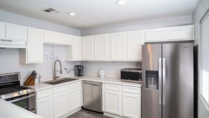 A modern kitchen with white cabinetry, stainless steel appliances, a dishwasher, and a built-in oven. - Quaint Central Phoenix Duplex   (Phoenix)
