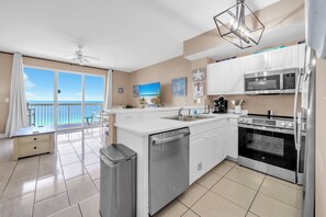 A modern kitchen with a view of the ocean, a dishwasher, a stove, and a microwave. - 🏖️Beach Front-FREE Beach Service-Pools-Celadon 1103🏖️ (Panama City)