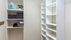 A walk-in closet with shelves, a hanging rod, and a door. - 1BR I Downtown, Queen, Free W/D, Garage (Fargo)