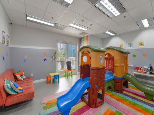 A play area with a slide, play structures, and colorful walls. - Gorgeous apartment in the heart of Brickell (Miami)