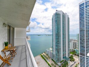 A balcony with a view of tall buildings and a body of water. - Gorgeous apartment in the heart of Brickell (Miami)