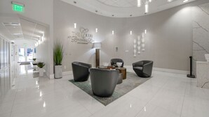 A modern lobby with a curved ceiling, a reception desk, and seating areas. - #3510 · Modern High-Rise Studio in Brickell (Miami)