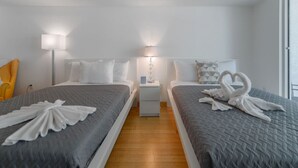 A hotel room with two beds, a nightstand, a lamp, and a window. - #3510 · Modern High-Rise Studio in Brickell (Miami)