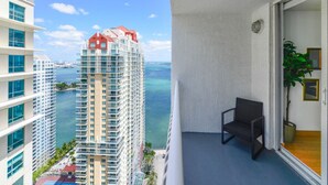A balcony with a view of a tall building and the ocean. - #3510 · Modern High-Rise Studio in Brickell (Miami)