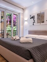 Una camera da letto con un letto, cuscini e asciugamani arrotolati.