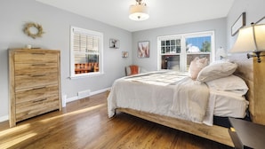 A bedroom with a wooden bed, a dresser, and a ceiling light.