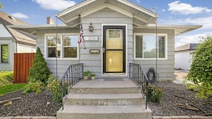 A single-story house with a front porch, a mailbox, and a small garden area.