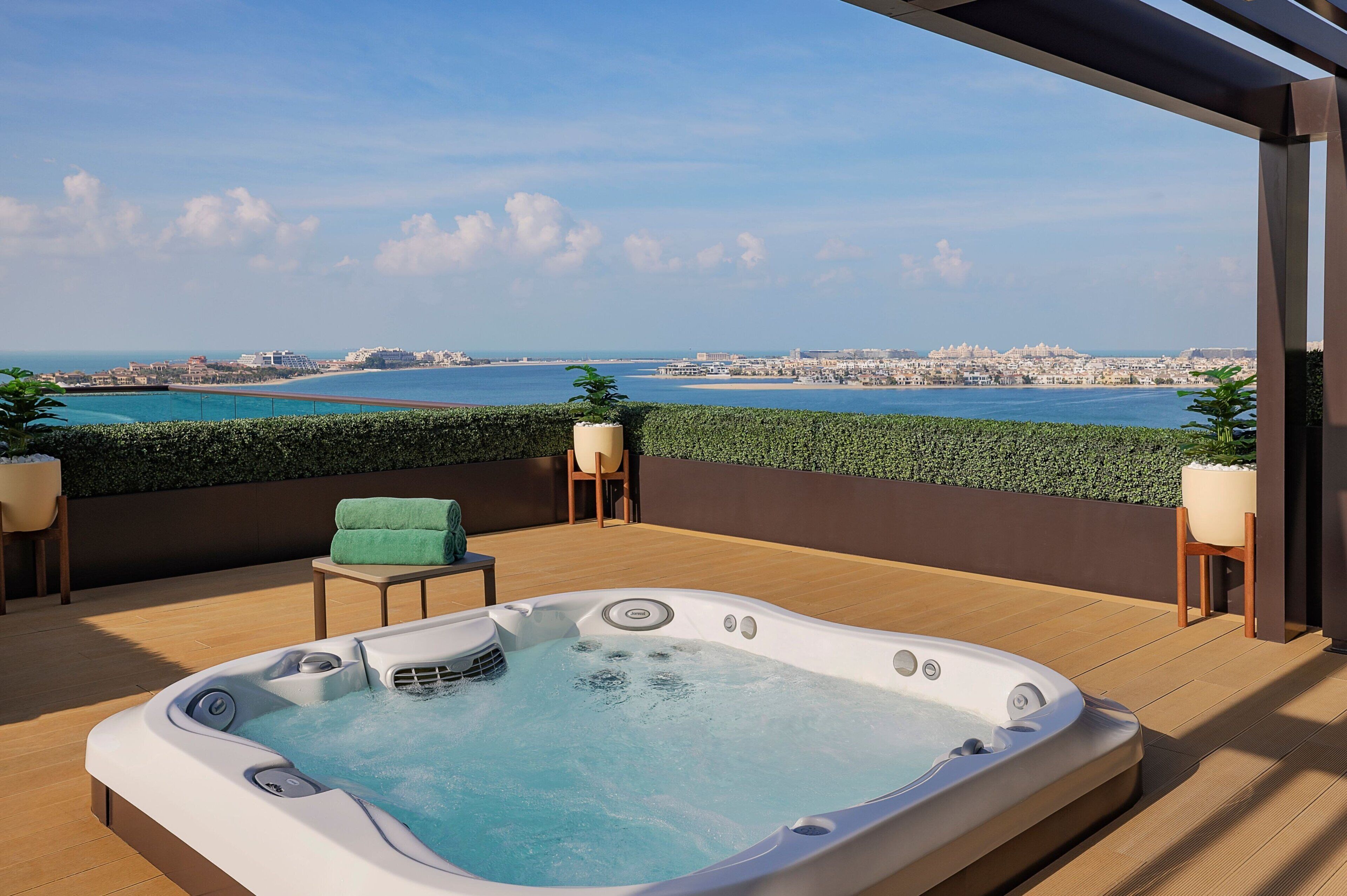Ein Whirlpool auf einer Holzterrasse mit Blick auf die Stadt.