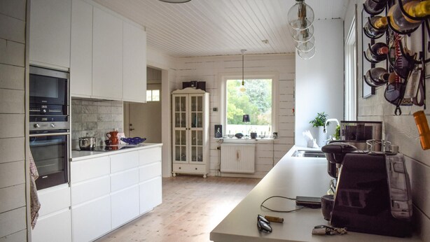 A modern kitchen with white cabinetry, a built-in oven, and a large window providing natural light. - Awesome home in Kalmar with WiFi (Virserum)