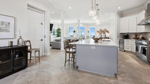 A spacious kitchen with a large island, modern appliances, and a view to the living area.