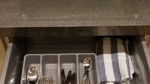 A drawer with compartments containing various kitchen utensils and a pair of yellow scissors. - London Luxury 1 bed studio 5 mins from Ilford Stn free parking (London)
