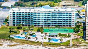A multi-story hotel with a pool area, tennis court, and beach access. - BEACHFRONT Ground Floor WALK-OUT 3Bdrm/2Ba Plantation Palms Great for Families (Gulf Shores)