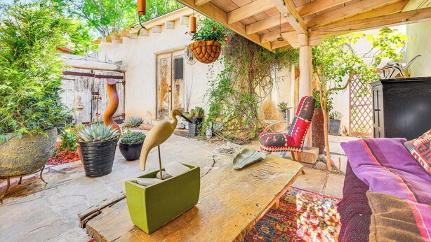 A cozy patio area with a wooden ceiling, potted plants, a rustic table, and a comfortable seating area. - Adobe Studio: 2 Blocks to Dtwn Santa Fe Plaza! (Santa Fe)