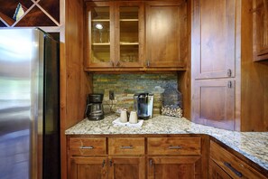 Una cocina con armarios de madera, un refrigerador de acero inoxidable, una cafetera y un tostador.
