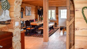 A rustic wooden interior with a dining area, wooden beams, and a cozy atmosphere.