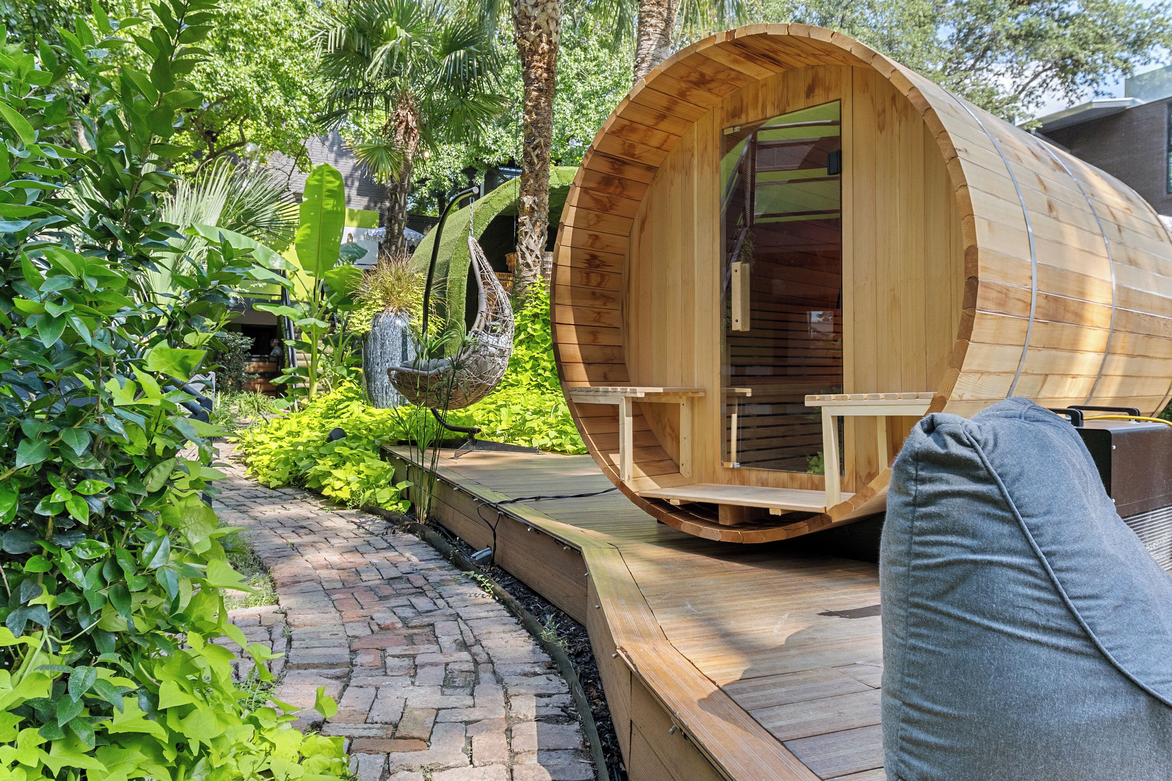 A wooden cylindrical structure with a door and a bench outside.
