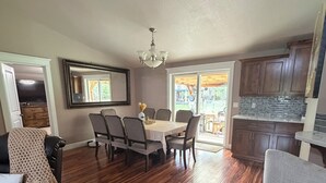 Un espace repas comprenant une table et des chaises, un lustre et un plancher en bois.
