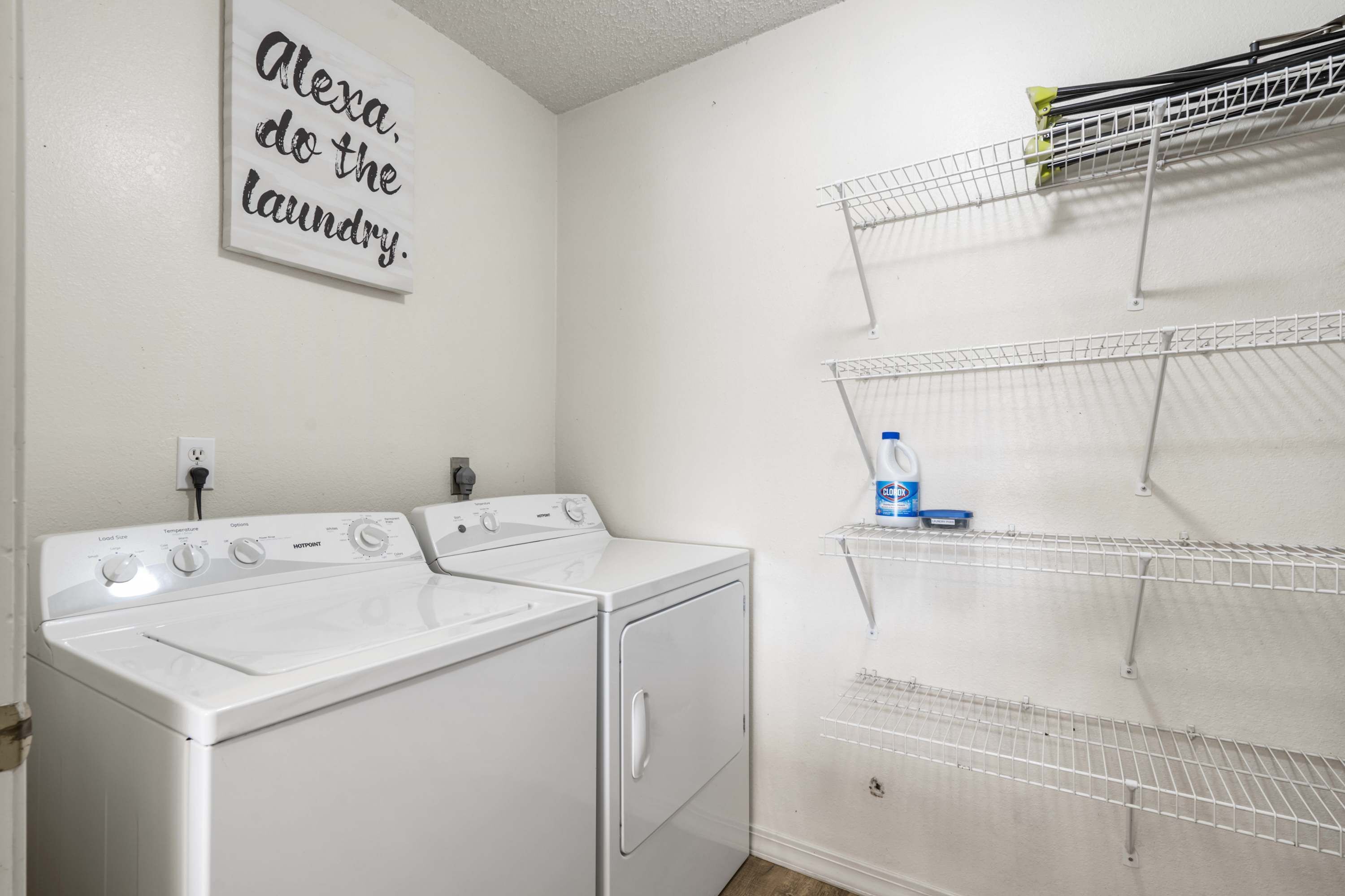 A laundry area with two white washing machines and a wall-mounted drying rack.