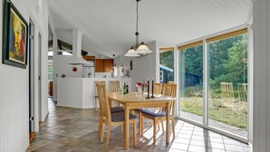A spacious kitchen with a dining area, large windows, and a view of the outdoors.