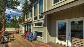 A two-story building with a wooden deck, outdoor seating, and a hot tub. - Hall Court Manor - Hot Tub, Pet Friendly, Pool Table! (Stateline)