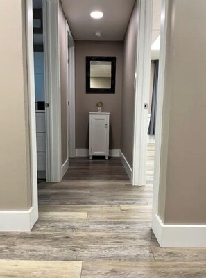 Stylish hallway with white doors and a small cabinet at the end.