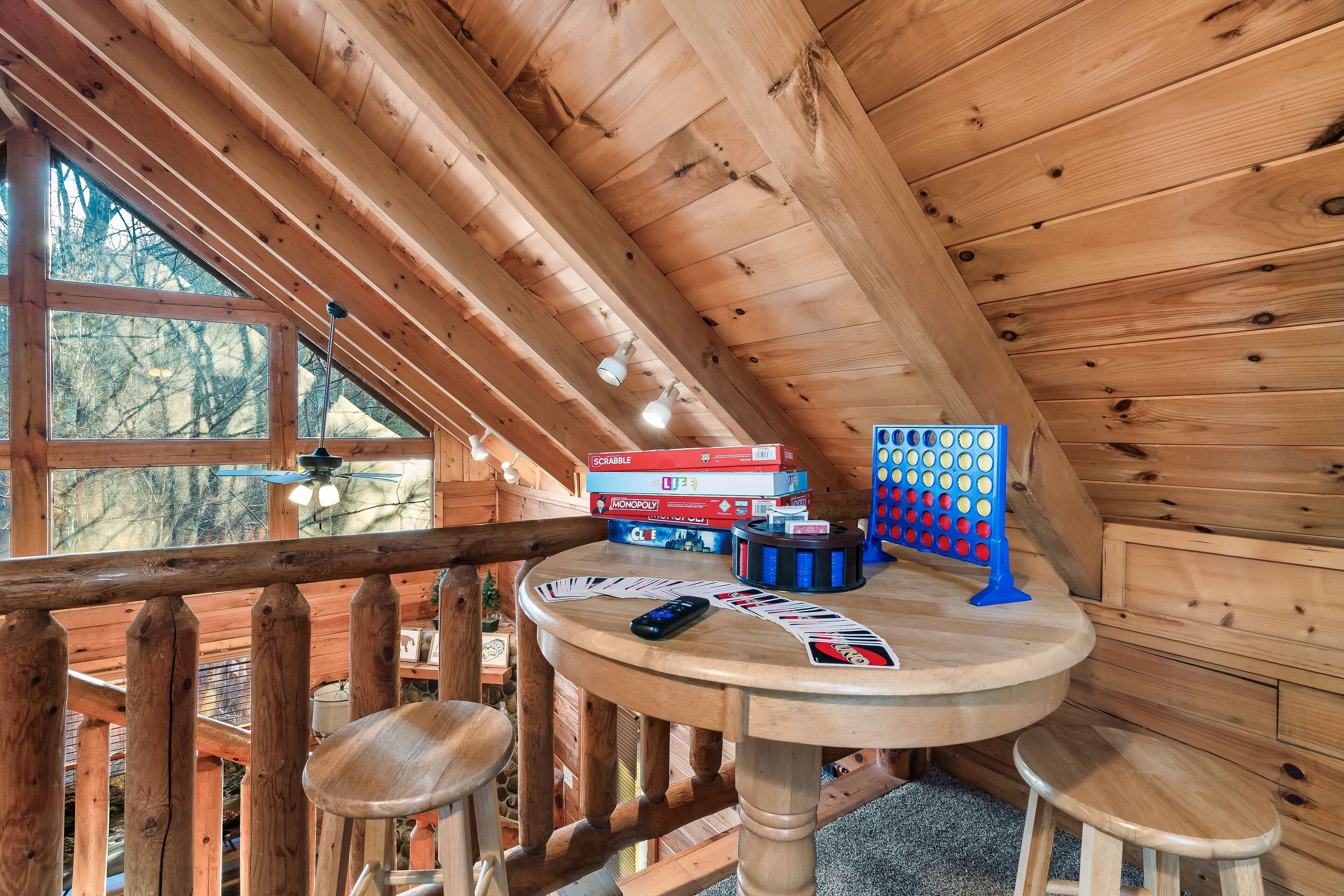 Een houten interieur met een ronde tafel, houten krukjes en een gezelschapsspel.