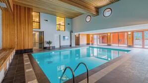 An indoor swimming pool with wooden paneling, a tiled floor, and a bench along the left side. - Centre-ville! Studio pour 4 + proche des remontées (Vaujany)