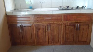 A kitchen with wooden cabinets, a countertop, and a gas stove. - Strandhaus am Meer, Langzeitmiete 485 Euro + Strom 30 Tg (San Fernando)