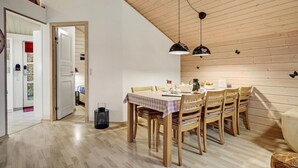 A dining area with a wooden table and chairs, a ceiling light, and a door leading to another room. - Awesome home in ørsted with WiFi (Ørsted)